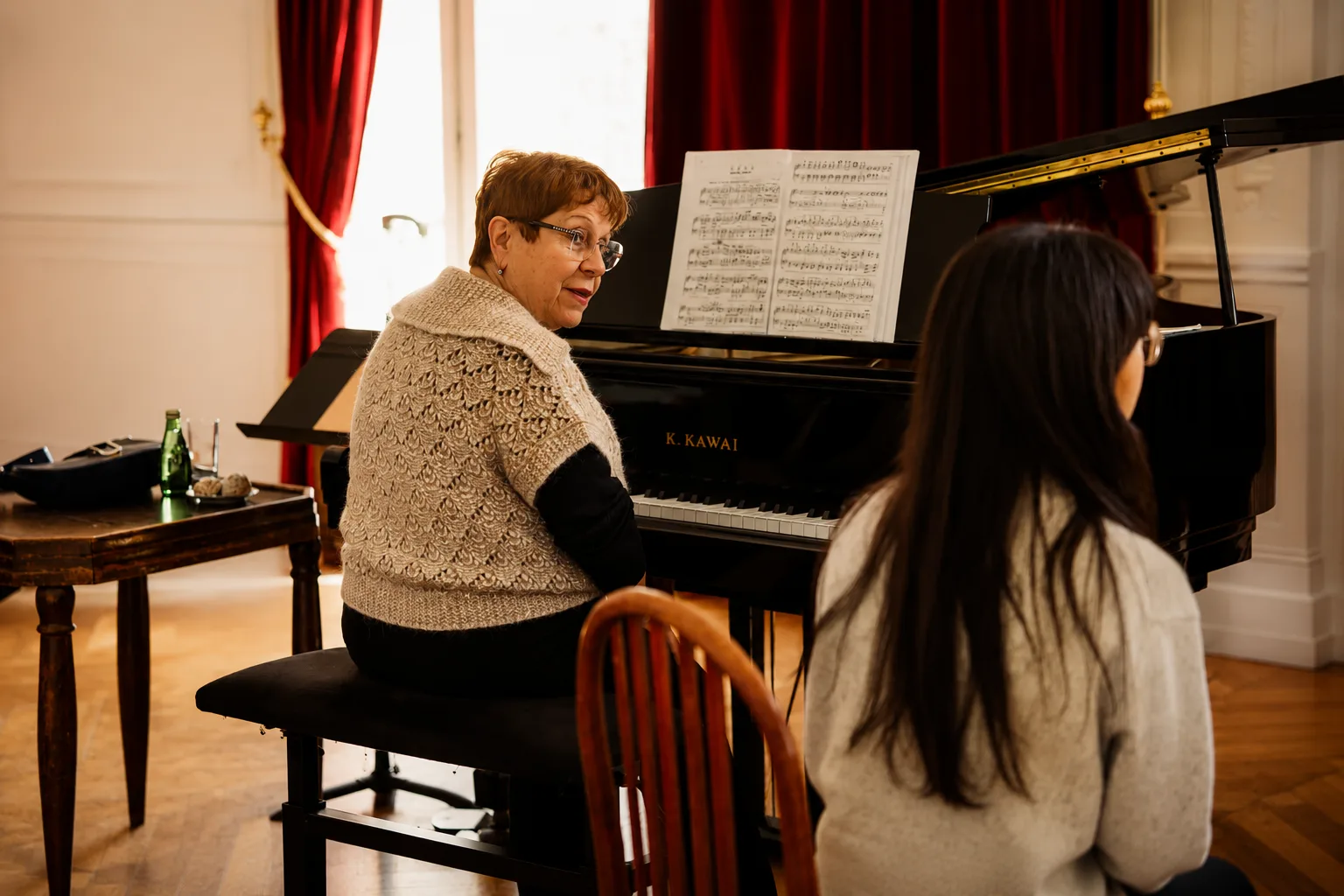 Professeure au piano en dialogue avec une élève pendant un cours individuel