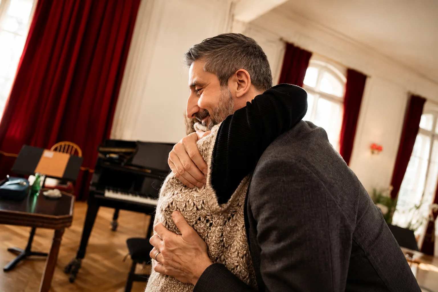 Accolade chaleureuse entre amis de l'Institut, salon avec piano à queue